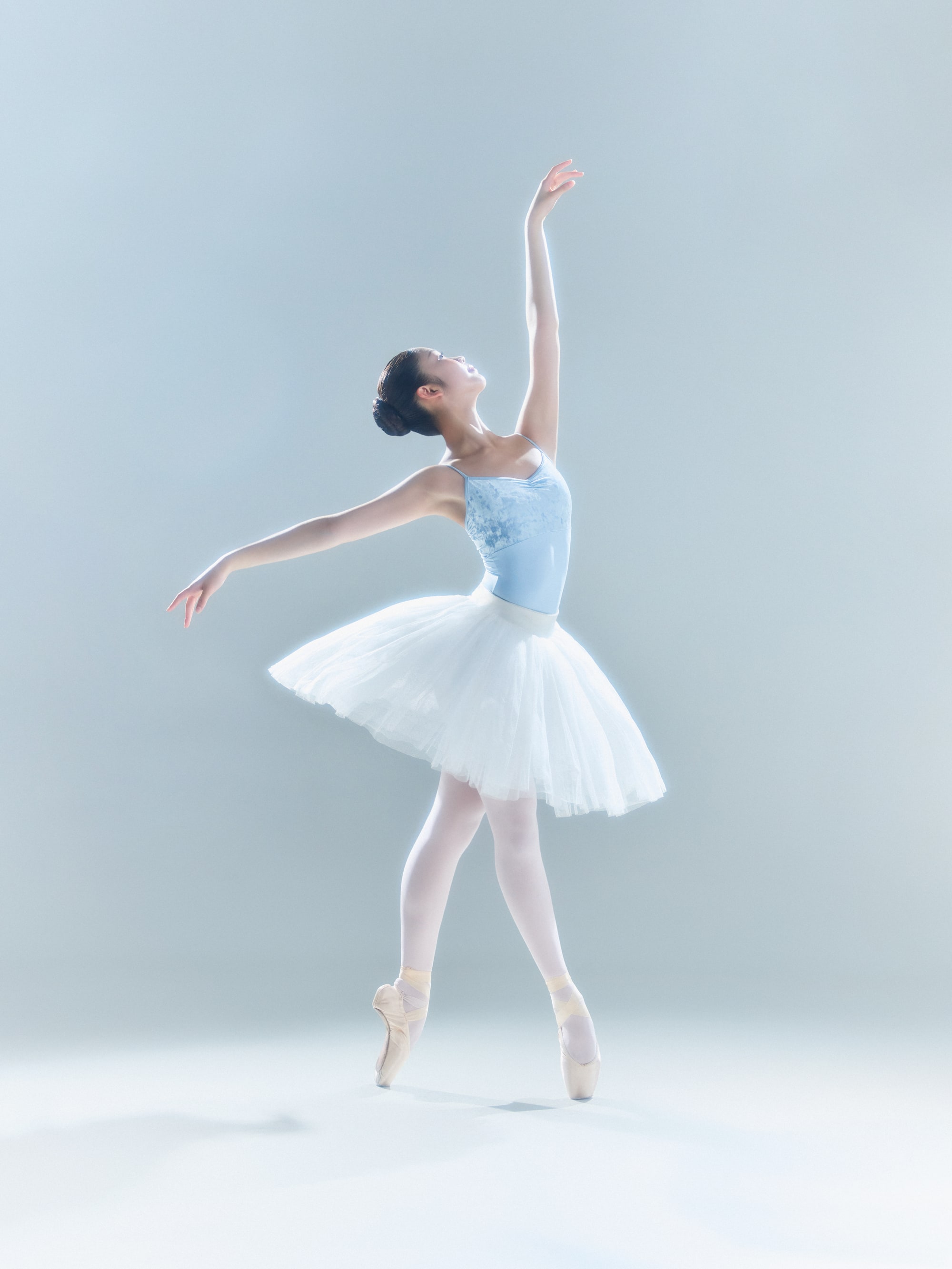 Sous-sus in a white classical tutu, one arm overhead