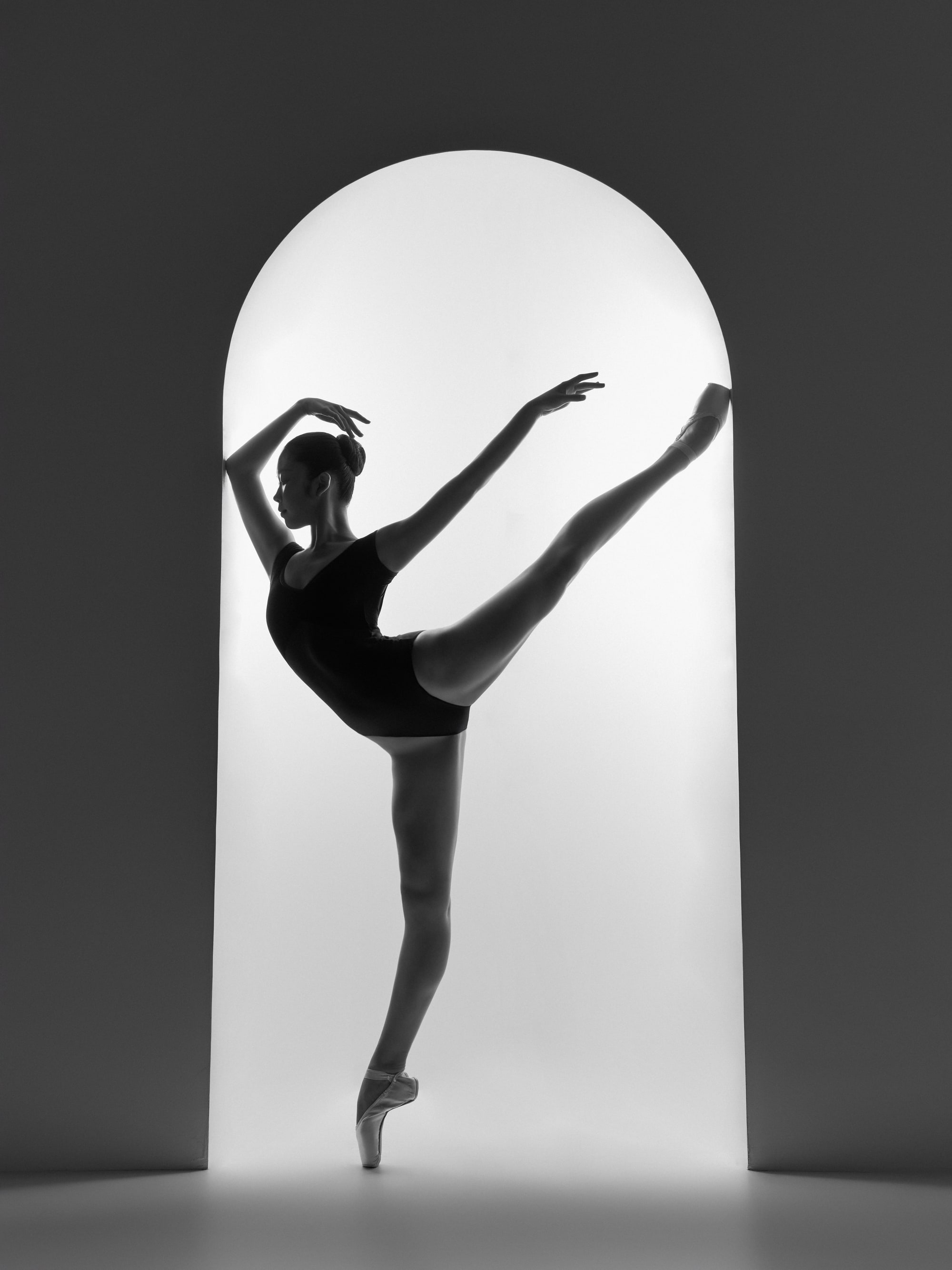Silhouette in an arched doorway, attitude with arms raised