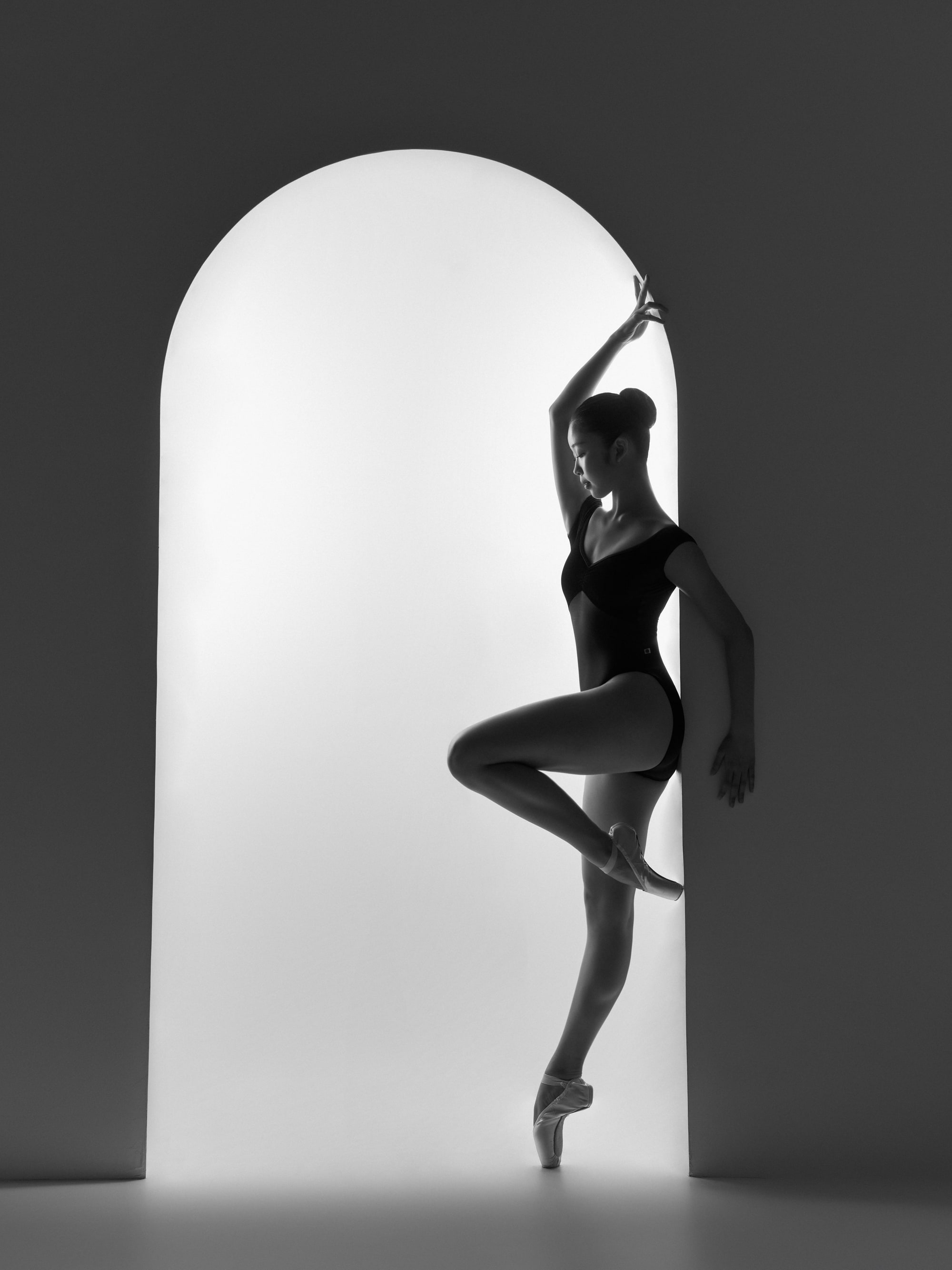 Silhouette in an arched doorway, retiré en pointe